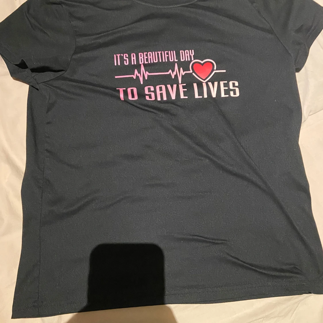Svart t-shirt med rosa text och hjärta