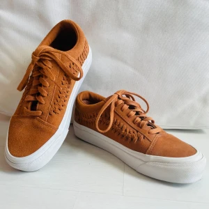 Bruna Vans sneakers i mocka, stl 37 - Snygga bruna Vans sneakers i mocka med flätad detalj på sidorna och klassisk vit sula. Knappt använda, nyskick. Har tydligen fått större fötter, så de passar tyvärr inte längre🤷🏻‍♀️