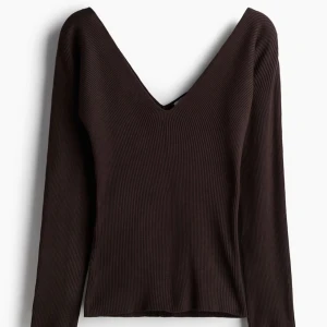 Brun ribbad v-ringad tröja - Mörkbrun ribbad tröja med djup v-ringning och lång ärm. Snygg och enkel modell som sitter skönt och passar perfekt till jeans eller kjol. Materialet är stretchigt och följsamt för en bekväm känsla.