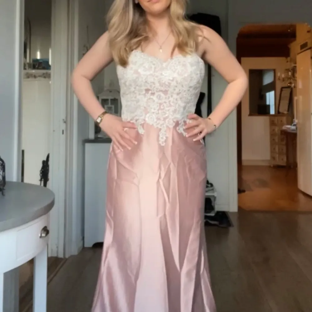Jätte ljusrosa balklänning med vit spets. Perfekt för bal eller festliga tillfällen. Aldrig använt, alltså är den helt ny! Skulle säga att klänningen passar någon som har 36/38. . Mekot.