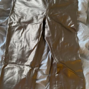 Guldiga jeansbyxor från Gina tricot - Säljer ett par metallic guldiga jeansbyxor från Gina tricot Perfect Jeans. Byxorna har klassisk femficksdesign, normal passform och stängs med knapp och dragkedja. Perfekta för dig som vill sticka ut med en glansig look.✨