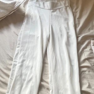 Vita vida lågmidjade byxor - Lågmidjade vida byxor med figurnära passform