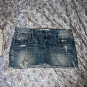 Jeanskjol med slitningar från Abercrombie & Fitch - Säljer en jeanskjol från Abercrombie & Fitch! Den är knappt använd och är i W28🥰🥰
