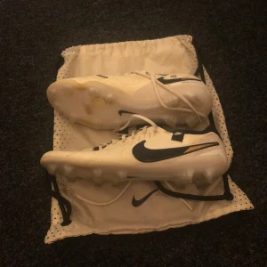 Nike tiempo elite fg beige Fotbollskor - Säljer ett par Nike tiempo elite fotbollsskor. Skorna har snörning och är utrustade med dobbar för spel på gräs. Modellen har märkningen 'FlyTouch Plus' på sidan och levereras med en vit Nike-påse. Har använt dem lite och dem har inte passat mig. Skorna är tvättade och ser ut som nya .(Förutom på bild 4)