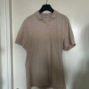 Beige piké t-shirt från Bläck - stilren beige piké t-shirt från Bläck i storlek M. nice nu till sommaren