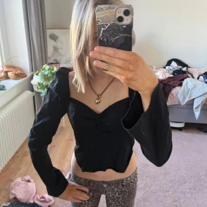 Svart långärmad topp - Snygg svart topp med långa ärmar och en v-ringad design. Ifrån nelly i storlek 34☺️ dragkedjan e lite trög! 