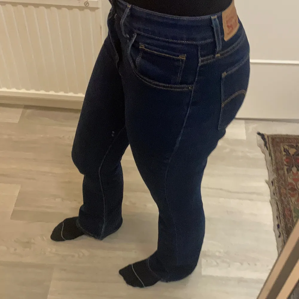 Snygga mörkblå jeans från Levi's med klassisk femficksdesign och guldfärgade sömmar. De har en hög midja och en slim passform som ger en smickrande siluett!!🩶🩶. Farkut & Housut.