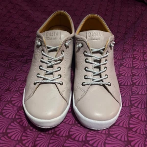 Beige sneakers från Dasia - Säljer ett par helt nya sneakers från Dasia. Då jag ångrade köpet men kan inte lämna tillbaka de. Skorna har snörning och en rund tå, vilket ger en klassisk look. 
