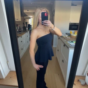 Gullig tubtopp - Säljer en svart jätte söt tubtopp med figurnära passform och utsvängd nederdel. Toppen är axelbandslös och har en stilren, enkel design som passar perfekt till många olika outfits. Skriv innan köp!❤️❤️