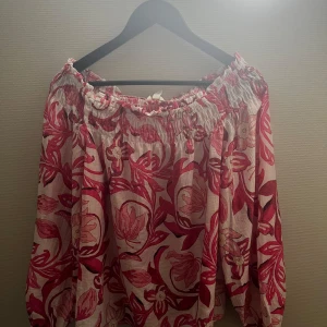 Blommig offshoulder blus i rosa och vitt - Supersöt blommig blus med offshoulder-modell i vitt och rosa. Lätt och luftig med resår upptill och långa ärmar. Perfekt för sommaren🩷🩷🩷