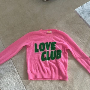 Rosa kashmirtröja från From Future - Superfin rosa kashmirtröja från From Future med grönt LOVE CLUB-tryck framtill. Tröjan har rund hals, långa ärmar och ribbade muddar. Perfekt statement-piece för dig som gillar färg och mjuka material. Supersnygg, säljer då den blivit lite liten. 
