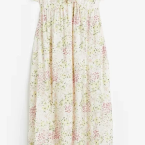 Blommig långklänning med volang - Långklänning med blommigt mönster i ljusa toner. Klänningen har smala axelband och volangdetaljer upptill. Använd fåtal gånger kommer från HM slutsåld