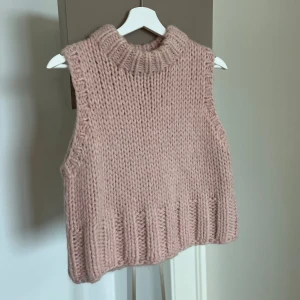 Stickad rosa väst från Zara - Supermysig stickad väst från Zara i ljusrosa nyans. Modellen är ärmlös med grovstickad struktur och ribbad hög krage samt nederkant. Endast använd 1 gång. Nypris 499