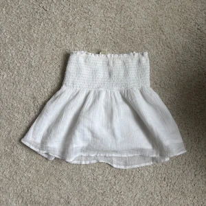 Vit volangtopp från Gina Tricot - Supersöt vit topp från Gina Tricot!! Funkar som kjol också men i huvudsak så är det en volangtopp!!