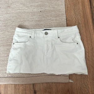 Vit jeanskjol från Pieces - Vit kort jeanskjol från Pieces med klassisk femficksdesign. Storlek M passar dock midre