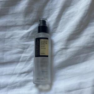 COSRX Advanced Snail 96 Essence - COSRX Advanced Snail 96 Mucin Power Essence i genomskinlig plastflaska med svart pump. Innehåller 100 ml essence med 96% snigelsekret, perfekt för återfuktning och glow. Lätt formula som absorberas snabbt och ger huden en fräsch känsla.