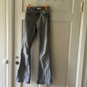 Grå bootcut jeans från Perfect Jeans - Snygga grå jeans från Perfect Jeans i bootcut-modell. Jeansen har klassisk femficksdesign, normal passform och är tillverkade i mjukt denimtyg. Perfekta för dig som gillar en retroinspirerad look med utsvängda ben.