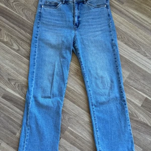 Blå raka jeans Carla Denim 1953 - Snygga blå jeans från Denim 1953 i klassisk rak modell. Jeansen har fem fickor, normalhög midja och är tillverkade i hållbar denim. Perfekta för en chill och stilren look.