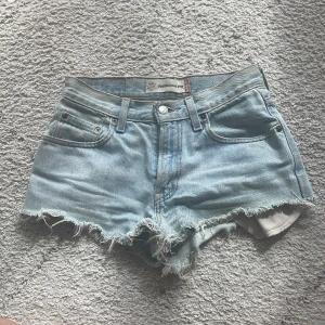 Levi's ljusblå jeansshorts med fransar - Snygga ljusblå jeansshorts från Levi's modell 560 Relaxed Fit. Skriv gärna om du är intresserad eller har frågor!!