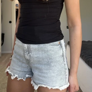 Ljusgråa jeansshorts - Säljer ett par ljusgråa jeansshorts med fransig kant nertill. Perfekta för sommardagar och ger en chill vibe till din outfit.