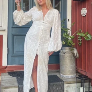 ADOORE KLÄNNING - Superfin populär adoore klänning med broderade blommor, v-ringning och knappar där de tre längst ner är utbytt hos en sömmerska men inget man tänker på! 