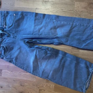 gråa wide jeans från BDG - Säljer ett par blåa jeans från BDG Urban Outfitters med bred passform och klassisk femficksdesign. Jeansen har dragkedja och knapp framtill samt snygga kontrastsömmar. 