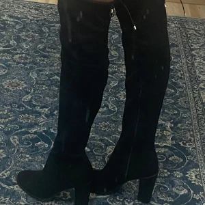 Svarta overknee stövlar med klack - ANVÄNDA EN GÅNG. PRIS KAN DISKUTERAS!Snygga svarta overknee stövlar med hög klack och rund tå. Stövlarna har snörning upptill och är gjorda i ett mockaliknande material som ger en lyxig känsla. Perfekta för att lyfta vilken outfit som helst.