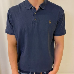 Marinblå pikétröja från Ralph Lauren - Säljer en as snygg mörkblå piké från Ralph lauren , den är i topp skick och modell classic fit, skriv för frågor eller likande 