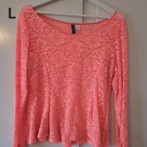 Aprikosfärgad spetstopp med lång ärm - Superfin topp från Gina Tricot i spets med blommigt mönster. Långärmad och med bred, rund halsringning. Perfekt för dig som gillar romantisk och feminin stil.