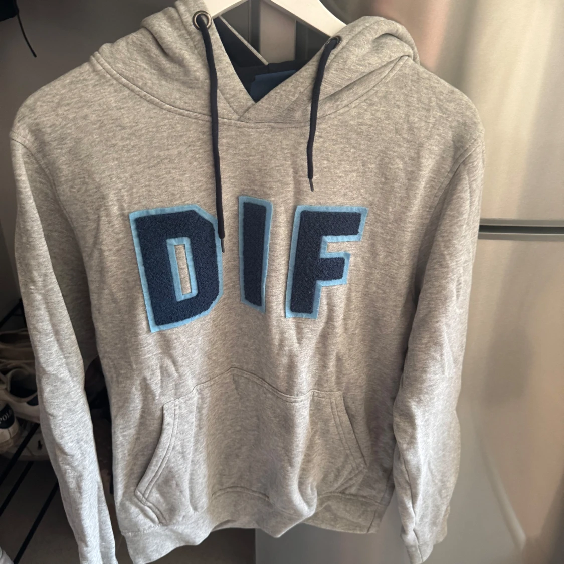 Grå DIF hoodie med blå bokstäver