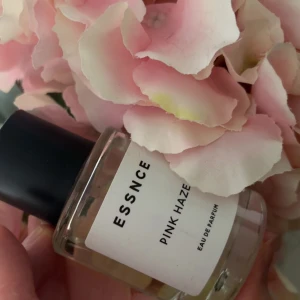ESSNCE Pink Haze Eau de Parfum - Fräsch parfym från ESSNCE i doften Pink Haze. Kommer i en stilren, rund glasflaska med svart lock och minimalistisk vit etikett. Perfekt för dig som gillar blommiga och lätta dofter. Flaskan är genomskinlig och känns modern och enkel. Använd få tal gånger då den inte föll mig i smaken 