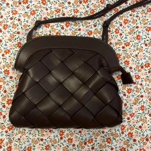 Brun axelväska i skinn från Carin Wester - Säljer en brun axelväska från Carin Wester i flätat skinn. Väskan har justerbar axelrem, dragkedja upptill❤️❤️🙌