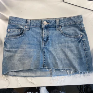 Jeanskjol - Gammal Jeanskjol från lindex strl 36. Har en liten fläck på framsidan som troligtvis går bort i tvätten. I övrigt bra skick. Midjemått mätt rakt: 37 cm. Hör av dig vid frågor❤️