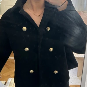 Svart jacka från Zara med guldknappar - Stilren svart jacka från Zara med guldknappar framtill. Jackan har klassisk krage, raka fickor och är tillverkad i ullblandning ⭐️