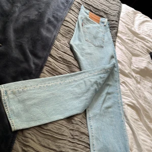 Levi's 501 ljusblå jeans straight fit - Klassiska Levi's 501 jeans i ljusblå denim med raka ben och hög midja. Snygg vintagekänsla, femficksmodell och ikonisk läderpatch bak. Perfekta för en avslappnad och tidlös stil. Riktigt fint skick, pris kan diskuteras 