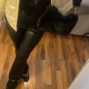 Svarta skinnbyxor med raka ben - Snygga svarta Lågmidjade skinnbyxor med raka ben och hög midja. Byxorna har en stilren look och passar perfekt till en trendig outfit. 