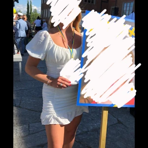 Studentklänning  - Säljer en söt vit kortklänning med puffiga kortärmar och rynkade detaljer framtill. Perfekt för sommaren/studenten. Storlek M men stretchig i materialet så passar även S/L