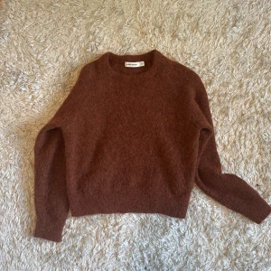 Brun stickad tröja från Carin Wester - Mysig brun stickad tröja från Carin Wester i storlek XS. Tröjan har rund halsringning och långa ärmar, perfekt för kyligare dagar. Enkel och stilren design som passar till mycket.