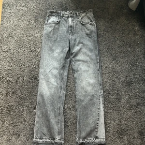 Svarta jeansbyxor från Zara - Säljer ett par svarta jeansbyxor från Zara med klassisk femficksdesign och flared ben. Byxorna har avslappnad passform och stängs med dragkedja och knapp. Perfekta för en stilren och avslappnad look.