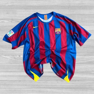 FC Barcelona fotbollströja Larsson 7 - Klassisk FC Barcelona matchtröja med Larsson 7 på ryggen. Tröjan är blå och röd med gula detaljer, klubbmärke på bröstet och LFP-patch på ärmen. Kortärmad modell i lätt och ventilerande material.