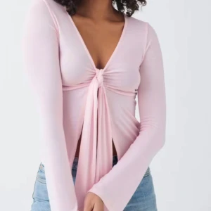 Ljusrosa långärmad topp med knyt från Gina Tricot - Supersöt ljusrosa långärmad topp från Gina Tricot med djup v-ringning och knyt framtill. Tunn och mjuk i materialet, perfekt att styla med jeans eller kjol. Endast använd 1 gång, säljer då den inte används💞