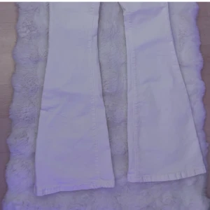 Vita bootcut jeans från SHEIN - Säljer ett par vita bootcut jeans från SHEIN i storlek S. Byxorna har hög midja och klassisk femficksdesign med knapp och dragkedja framtill. Perfekta för dig som gillar en retroinspirerad look med utsvängda ben.