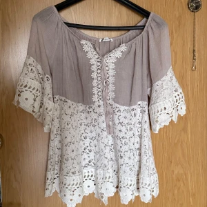 blus med spetsdetaljer - Superfin tunn blus med vita spetsdetaljer och blommigt mönster. Vida trekvartsärmar med spetskant och v-ringning framtill. Perfekt för vår och sommar!