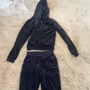 Mörkblå Juicy Couture set (kofta+byxor) - Mörklbå Juciy Couture set i velour. Båda för 600kr. Har använts ganska mycket men har inga tydliga tecken på användning. 