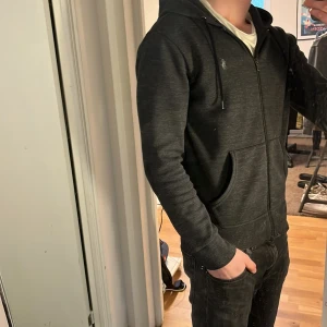 Ralph Lauren Zip Performance Hoodie - Tja säljer nu en riktigt snygg Ralph lauren hoodie i storlek s och i färgen svart/grå i performance material. Hoodien är i ett fint skick utan några defekter som hål eller fläckar. Nypris 1395kr mitt pris 449kr. Hör av dig vid frågor eller funderingar! Pris ej hugget i sten!