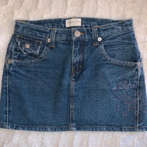 Jeanskjol  - Säljer en blå jeanskjol från twopercent med söta rosa detaljer💕