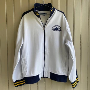 Ralph Lauren zip up - En mycket fin Ralph Lauren zip up lite mer åt vintage och collegetröja hållet. Det finns en liten fläck ungefär mitt på tröjan men den syns inte under användning.   Måtten är ca 70 i längd och 50 i axelbredd.  Tveka inte på att skriva om du har några frågor!!💬