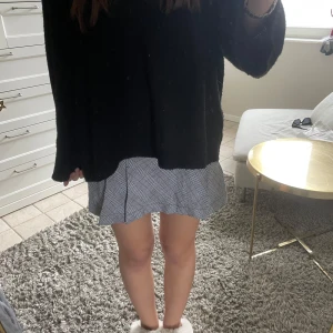 Grå rutig kortkjol - Säljer en grå kortkjol med rutigt mönster. Kjolen har en lätt utsvängd form och sitter snyggt i midjan. Perfekt att styla med en stickad tröja eller t-shirt 💗