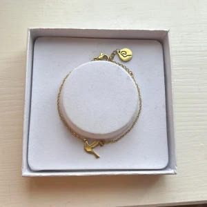 Guldarmband med fågelberlock Edblad  - Snyggt och stilrent armband i guld med en liten fågelberlock. Tunn kedja och enkel design som passar perfekt för dig som gillar minimalistiska smycken. Lås med liten rund detalj. Från Edblad, tyvärr så medföljer inte orginal lådan💗Nypris 249kr mitt pris 75kr💗Kom gärna med prisförslag!