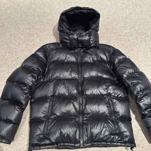 Svart pufferjacka från Polo Ralph Lauren - Säljer en svart pufferjacka Polo Ralph Lauren med huva och dragkedja. Jackan har två snedställda fickor med dragkedja och klassisk broderad logga på bröstet. Perfekt för kyliga dagar och riktigt snygg streetstil. Priset går att diskutera alltså inte hugget i sten annars om de finns några funderingar tveka inte att höra av er, jackan är använd några veckor då den var för stor på mig, beställde den på Ralph laurens hemsida för 6999 jackan går inte att få tag på längre då den ej tillverkas str L 